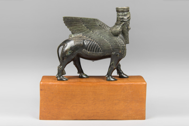 An antique bronze lamassu on a later wooden base. Price realised £600