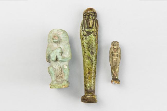 A group of ancient Egyptian artifacts, including a shabti figure and two figural faience amulets. Price realised £450.
