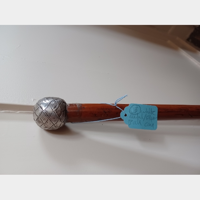 Walking cane with white metal ball